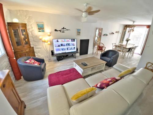 a living room with a white couch and a tv at Villa Confort Jacuzzi Barbecue Clim Parking in Marseille