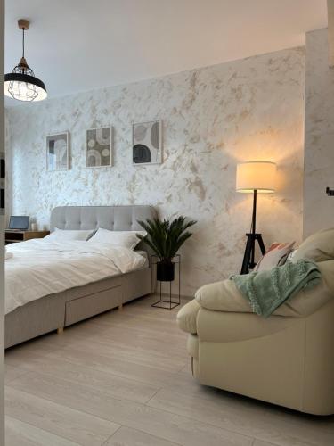 1 dormitorio con 1 cama grande y 1 sofá en Studios & Apartments Palas by GLAM en Iaşi
