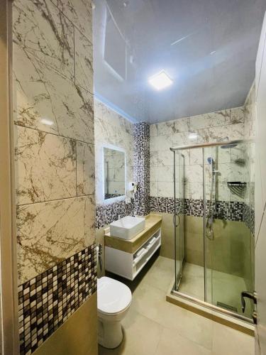 a bathroom with a toilet and a shower and a sink at DADIANI Inn in Zugdidi