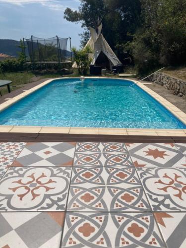 a swimming pool with a patterned floor and a tile floor at Tipis La Paix retrouvée in Tourrette-Levens