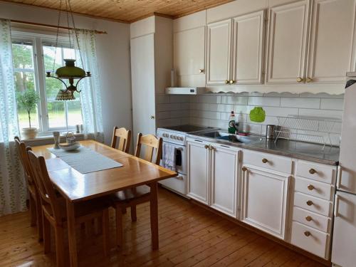 a kitchen with a wooden table and a table and a dining room at Trevlig och havsnära stuga in Glommen