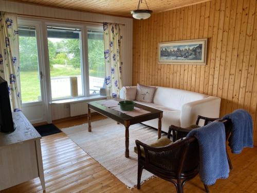 a living room with a couch and a table at Trevlig och havsnära stuga in Glommen