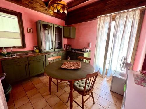 a kitchen with a table and chairs and pink walls at Marnabianca Apartment in Realmonte