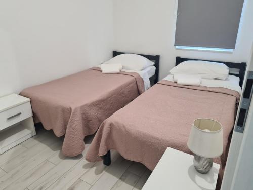 Kleines Zimmer mit 2 Betten und einem Tisch in der Unterkunft Apartman Lena in Zadar