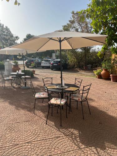 a table and chairs under an umbrella on a patio at Da Tea in San Teodoro