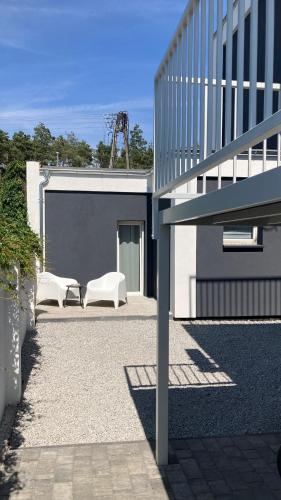 a building with two white chairs in a courtyard at Apartamenty Skórzewo in Skórzewo