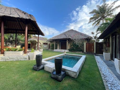 a backyard with a swimming pool and a house at Seaside Villa Kecil in Sekotong