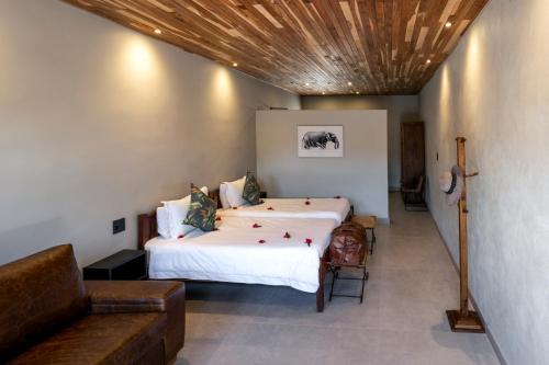 a bedroom with a large bed and a couch at Chobe River Lodge in Kasane