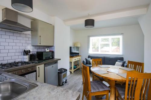 a kitchen and dining room with a table and chairs at Ground floor flat with parking, sleeps 3 in Wheatley