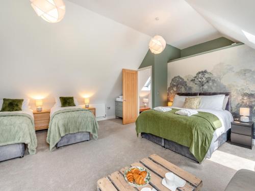 a bedroom with two beds and a table at Dower House Lodge in Lindridge