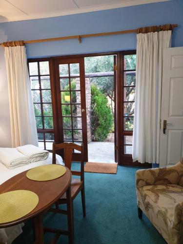 um quarto com uma cama, uma mesa e um sofá em Springfontein Guesthouse em Springfontein