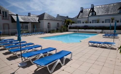 洛克馬里亞的住宿－Retour de plage，一组蓝色的躺椅和一个游泳池