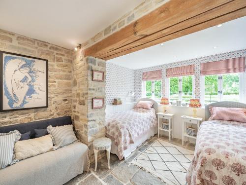 a bedroom with two beds and a couch at The Coach House in Creech Saint Michael