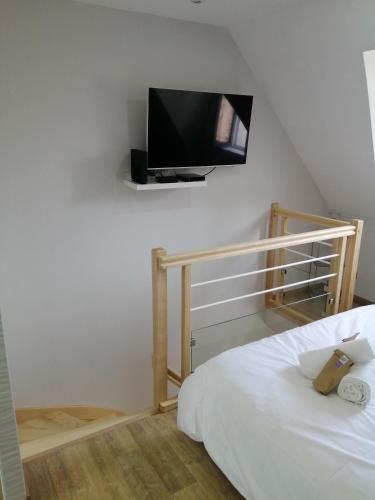 une chambre avec un lit et une télévision à écran plat au mur dans l'établissement L'escapade balnéo, à Béthune