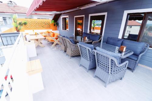 a patio with wicker chairs and tables on a house at Hotel Ipekyolu in Sapanca