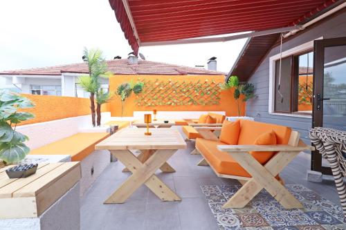 an outdoor patio with orange chairs and tables at Hotel Ipekyolu in Sapanca