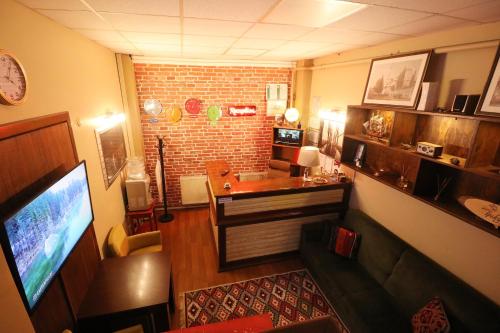 فندق إبيكيولو في صبنجة: غرفة معيشة فيها تلفزيون وجدار من الطوب