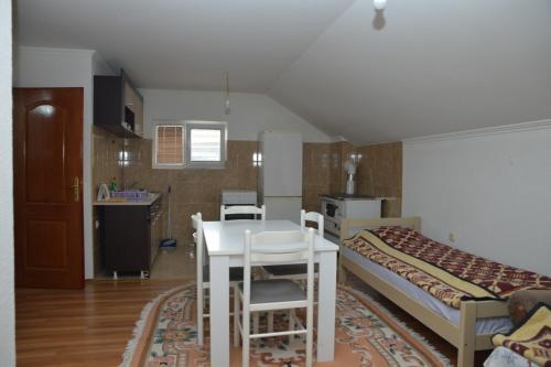 a room with a table and a bed and a kitchen at Apartmani Previja in Berane