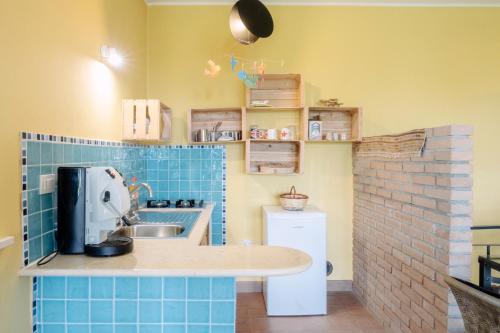 a small kitchen with blue tiled walls and a sink at Casa Lunaria in Moscufo
