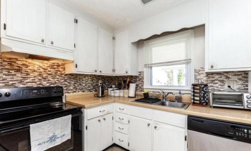 a kitchen with white cabinets and a black appliances at Cooper in Fort Washington