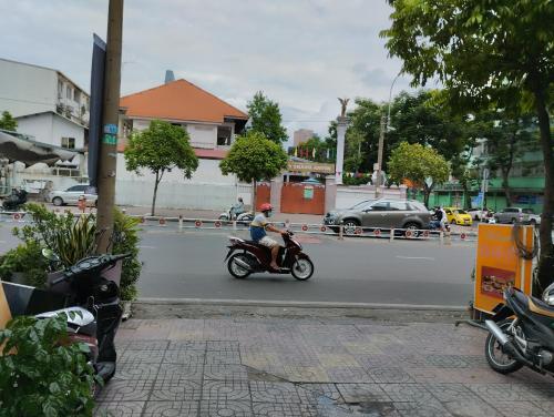 a person riding a motorcycle down the street at Dragon homestay centre city Bitexco view room in Ho Chi Minh City