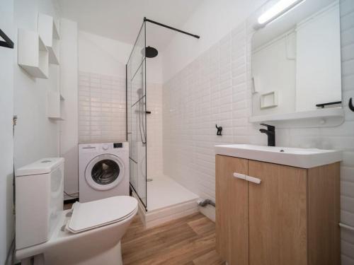 y baño con aseo, lavabo y lavadora. en Appartement Climatisé tout équipé 4 couchages à 6 minutes de la gare St Charles, en Marsella