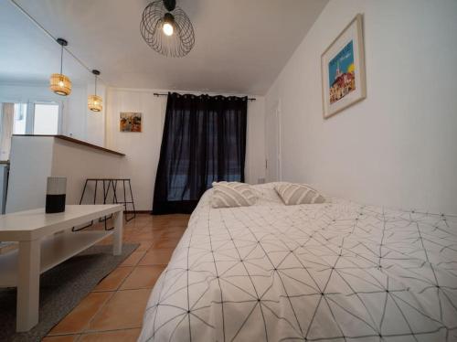 sypialnia z łóżkiem, stołem i oknem w obiekcie Appartement Climatisé tout équipé 4 couchages à 6 minutes de la gare St Charles w Marsylii