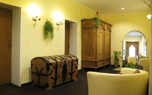a living room with a couch and a ottoman at Hotel Winter in Schöppingen