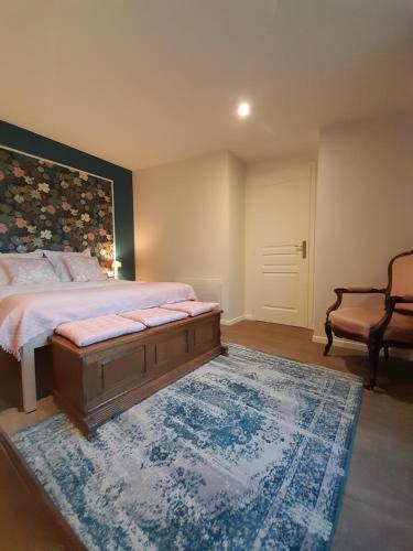 ein Schlafzimmer mit einem großen Bett und einem blauen Teppich in der Unterkunft Les Cottages du Chateau de Werde in Matzenheim
