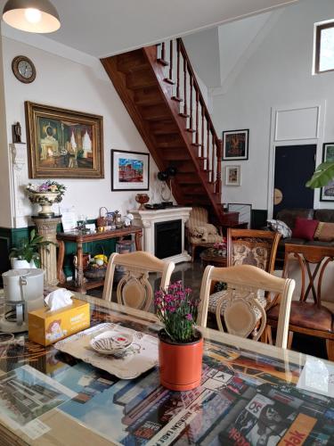 a living room with a glass table and chairs at The Castle Stay in Chuncheon