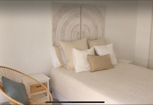 Una cama con almohadas y una silla en una habitación. en Beach Studio Juan Les Pins, en Antibes