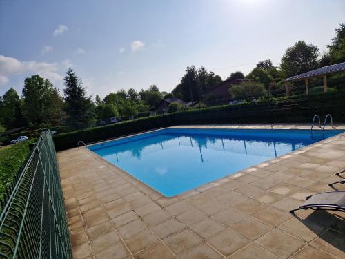 a large swimming pool with a fence around it at Chalet moderne au bord d'un lac in Saint-Sauveur-lès-Bray
