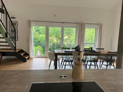 uma sala de estar com uma mesa de jantar e cadeiras em Forest Retreat- Serene 160m2 with Forest Views em Wermelskirchen