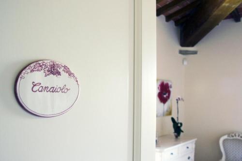een bord op een muur naast een deur bij Agriturismo la Concezione in Castiglion Fibocchi