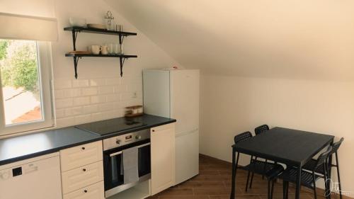 a small kitchen with a table and a refrigerator at Apartmani Matiša in Lastovo