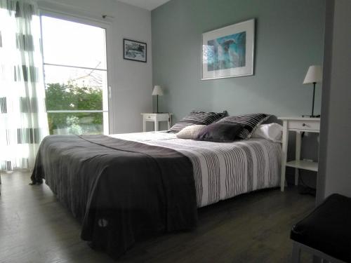 ein Schlafzimmer mit einem großen Bett und einem Fenster in der Unterkunft Villa Inizan in Loctudy
