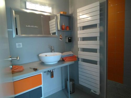 ein Bad mit einem Waschbecken und einem Spiegel in der Unterkunft Villa Inizan in Loctudy
