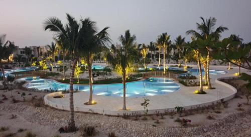 a large pool with palm trees in a resort at Blue Hawana in Salalah