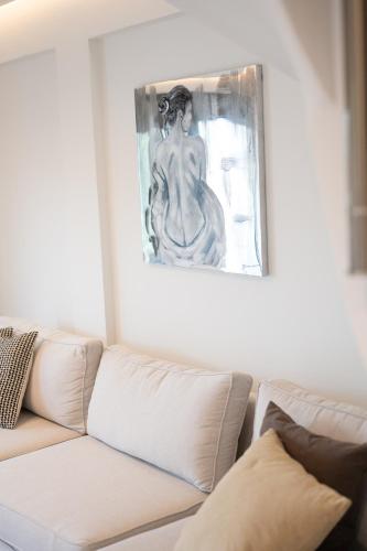 a living room with a couch and a painting on the wall at MiLiON RESIDENCES in Parga