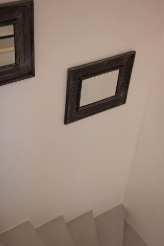 two mirrors on a white wall next to a shelf at MiLiON RESIDENCES in Parga