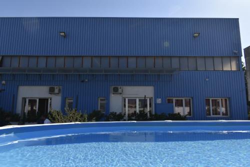 un edificio blu con una piscina di fronte di Ostello Salento ad Alezio