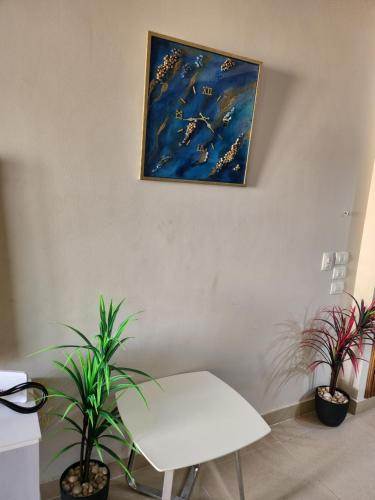 a white table and two potted plants on a wall at Azha Ain Sokhna apartment in Ain Sokhna