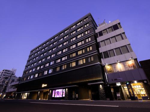 a tall black building on a city street at La'gent Hotel Kyoto Nijo in Kyoto