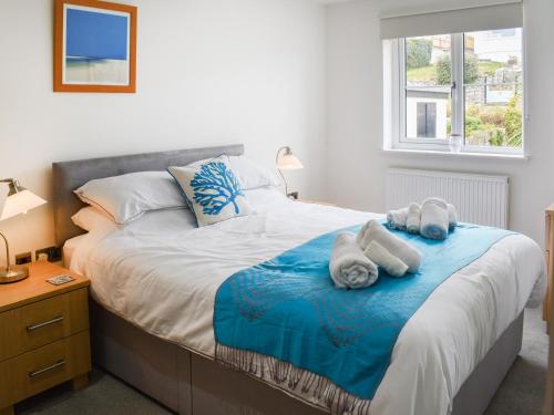 a bedroom with a large bed with towels on it at Puffling in Falmouth