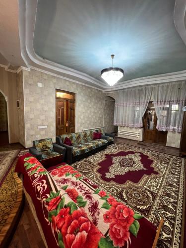a large living room with a couch and a rug at Lovely home in Osh