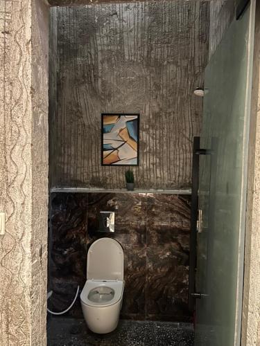 ein Bad mit einem WC und einem Wandgemälde in der Unterkunft شاليهات كورال بارك in Al Kura