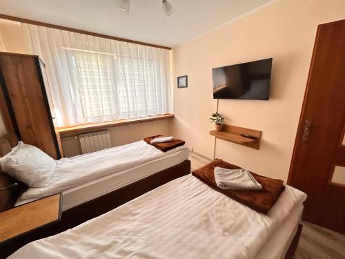 pokój hotelowy z 2 łóżkami i telewizorem z płaskim ekranem w obiekcie APARTAMENT TYCHY MIASTO 60m2 w Tychach