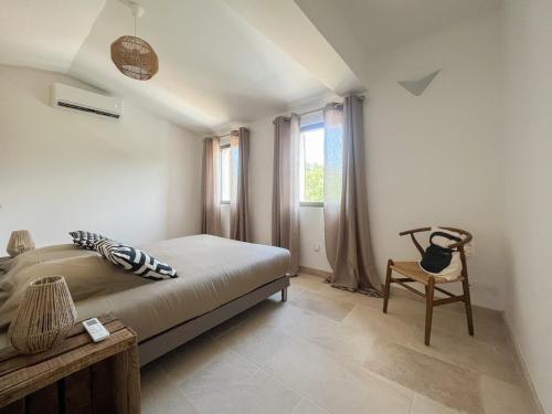 una camera da letto con un letto, una sedia e una finestra di La Mirande à Lacoste a Lacoste