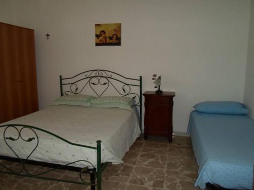 een slaapkamer met een bed en een nachtkastje en een bed sidx sidx sidx sidx bij casa rosa in Tiggiano