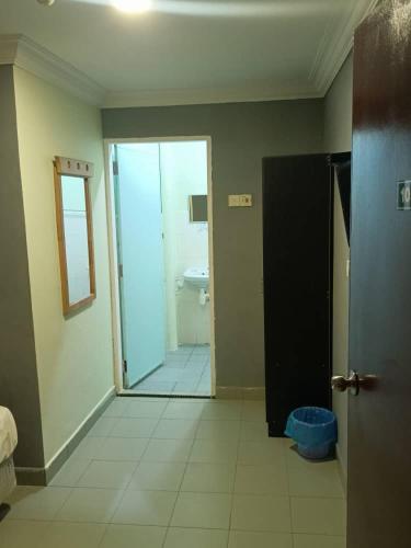 a room with a bathroom with a toilet and a door at FAMILY HOTEL in Kuala Kubu Baharu